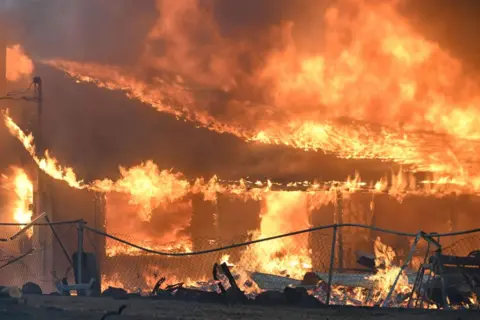 Getty Images Smoke and flames rise from the forest as crews try to extinguish a wildfire in Chico, California, United States on July 25, 2024. (Photo by Tayfun Coskun/Anadolu via Getty Images)